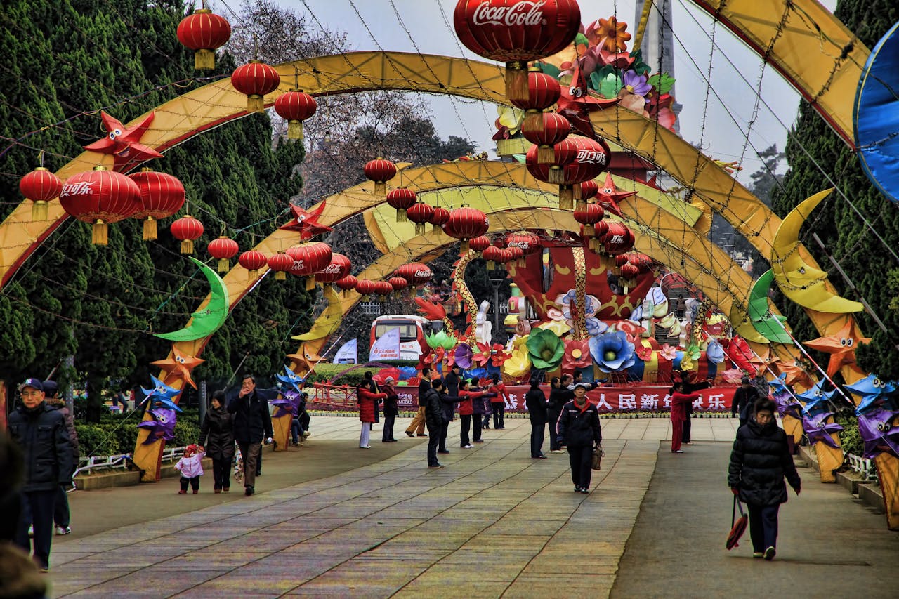 People Walking among Colorful Decorations above a Sidewalk
